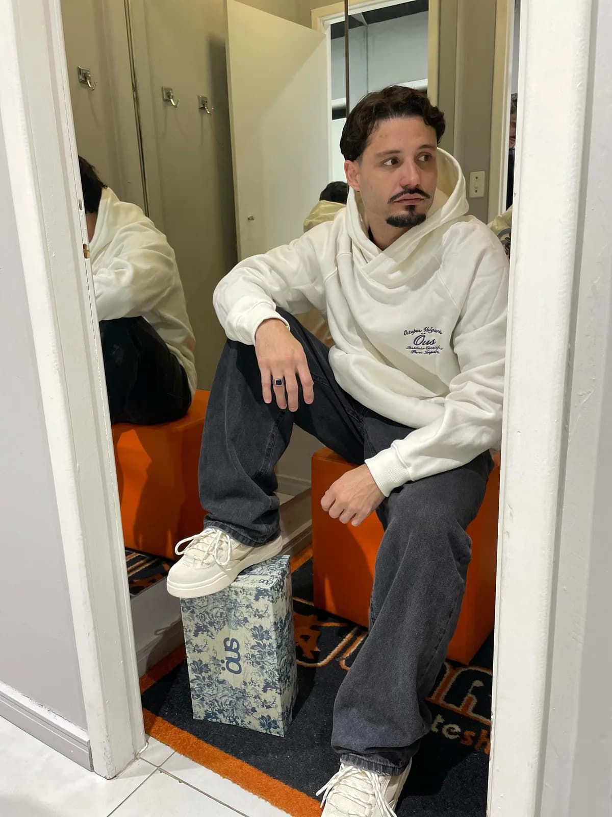 O kit na loja: moletom ÖUS off white e tênis ÖUS, no provador da Hard